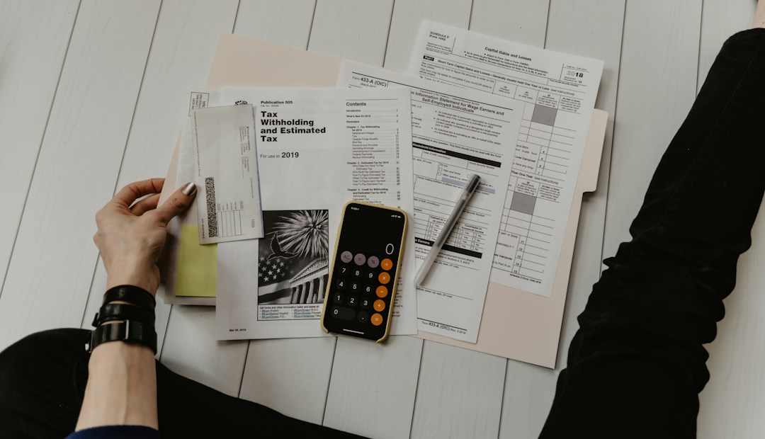 Person reviewing financial paperwork beside a calculator