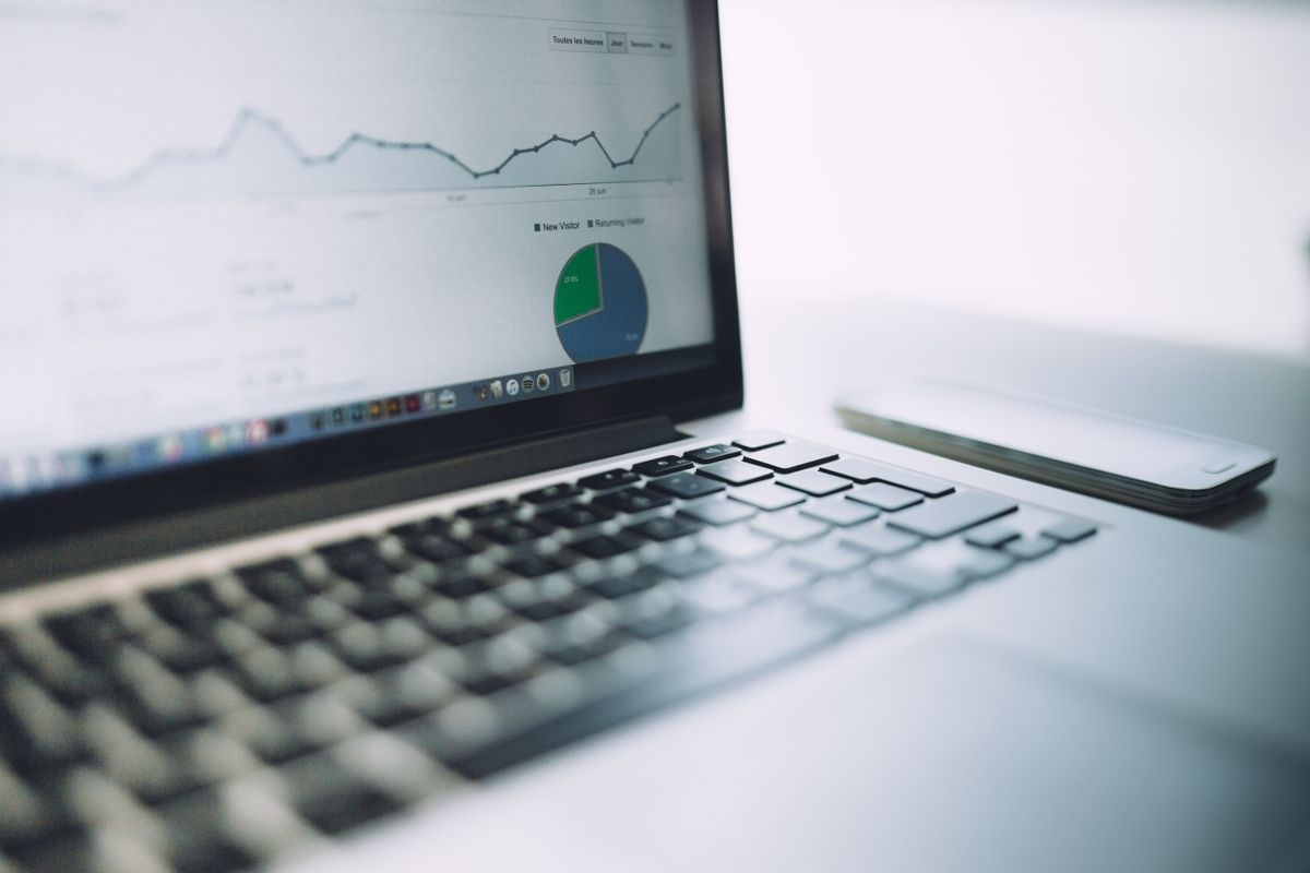 Laptop showing website traffic charts with new and returning visitors