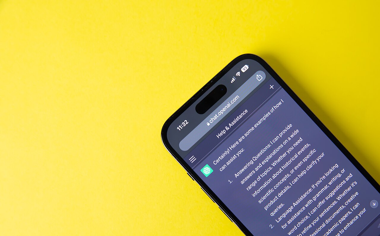 Mobile phone displaying ChatGPT on a yellow background