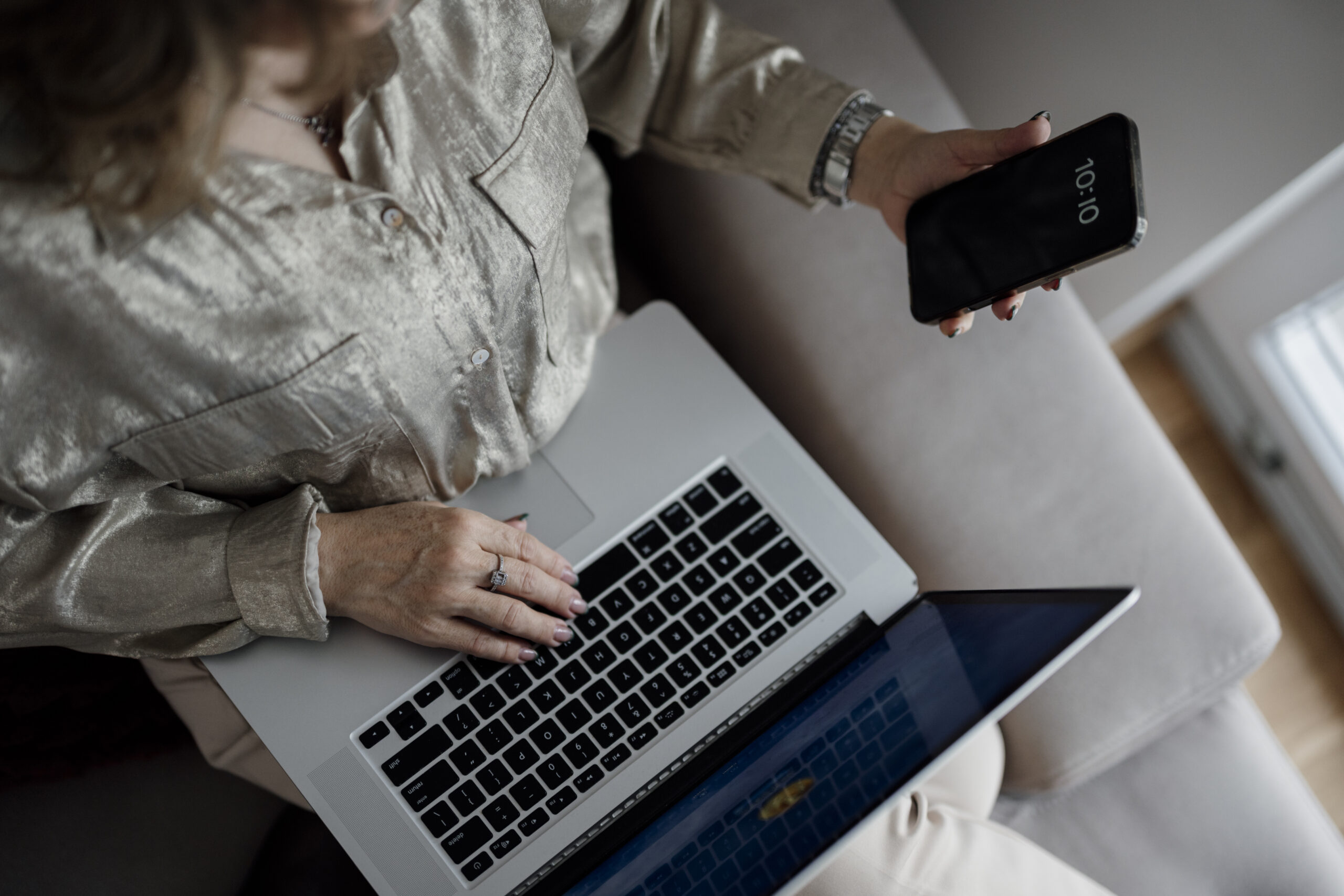 Person using a laptop and smartphone at home, trying free AI chatbot apps