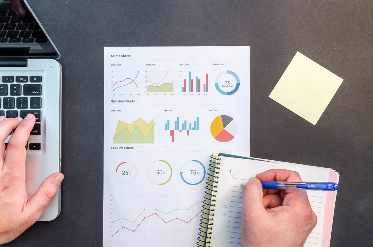 Printed website reports and a notebook on a desk during a monthly site review